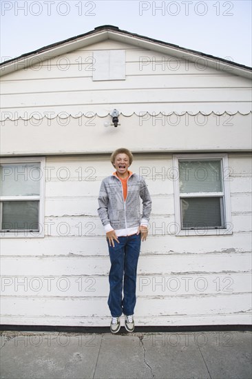 Mixed race boy jumping in mid-air