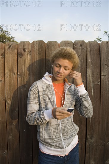 Mixed race boy listening to mp3 player