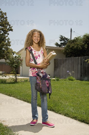 Mixed race girl carrying books