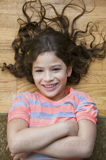 Smiling Hispanic girl laughing on floor