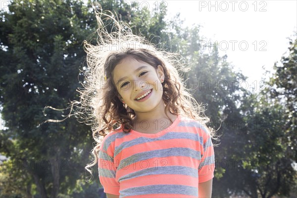 Smiling Hispanic girl standing outdoors