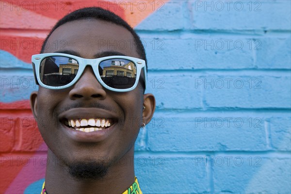 Close up of Black man wearing colorful sunglasses
