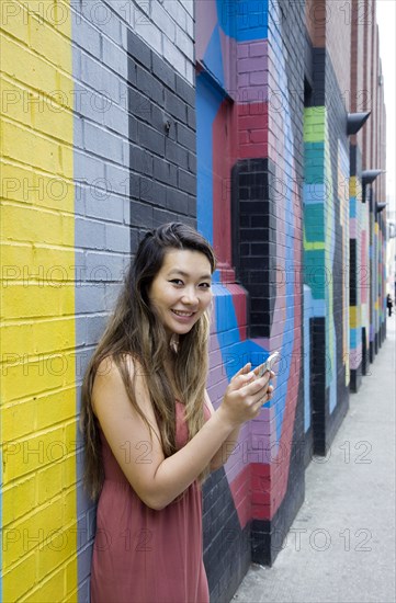 Asian woman using cell phone outdoors