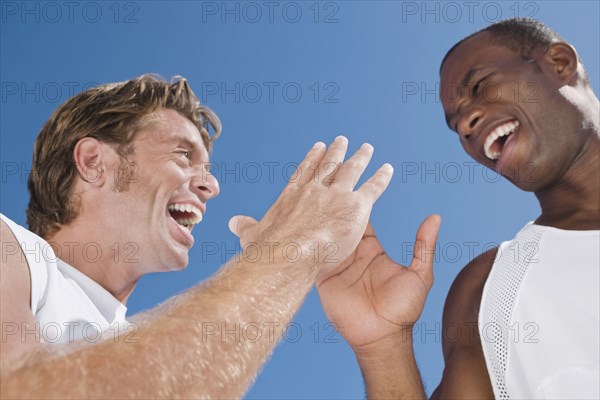 Multi-ethnic men high-fiving