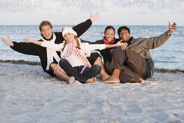 Multi-ethnic couples sitting on beach