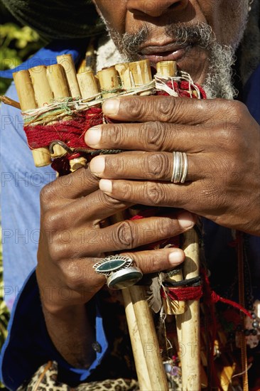 Close up of African man playing pan flute