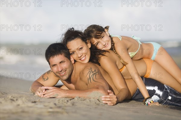 Hispanic family laying on beach