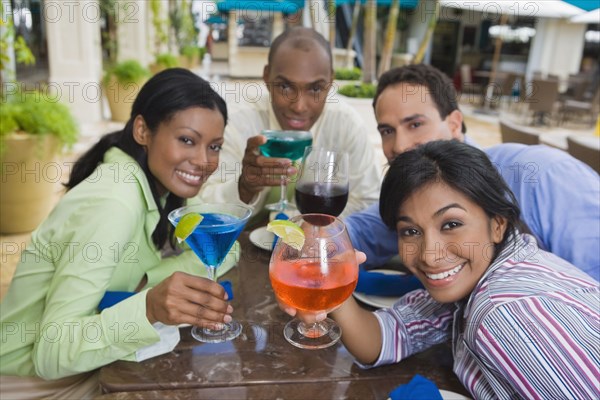 Hispanic couples toasting with cocktails