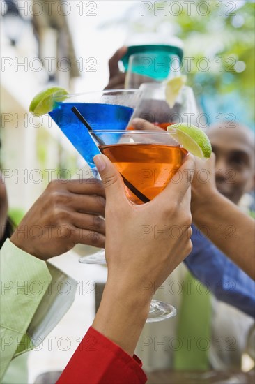 Hispanic friends toasting with cocktails