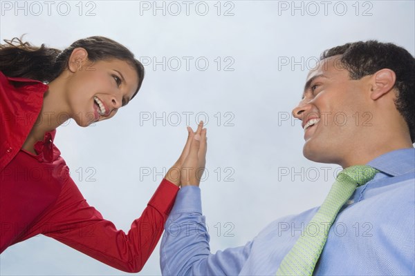 Hispanic business people high-fiving