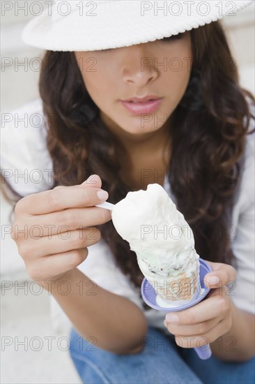 Hispanic woman eating ice cream cone