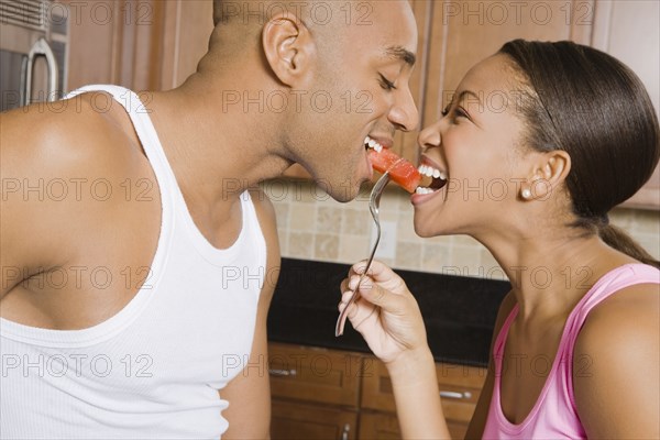African couple eating piece of fruit