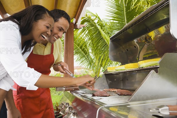 Multi-ethnic couple barbecuing