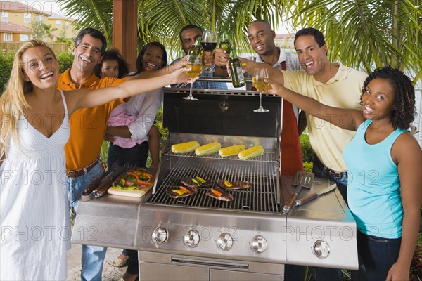 Multi-ethnic friends toasting over barbecue grill