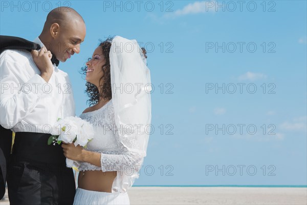 Multi-ethnic bride and groom smiling at each other