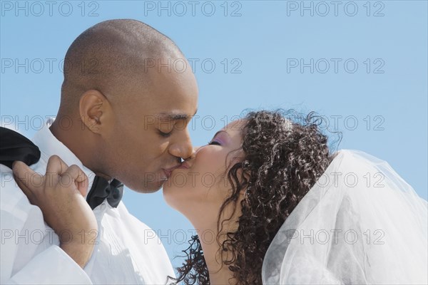 Multi-ethnic bride and groom kissing