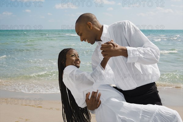 African couple dancing at beach