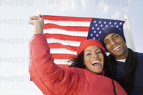 Multi-ethnic couple in front of American flag