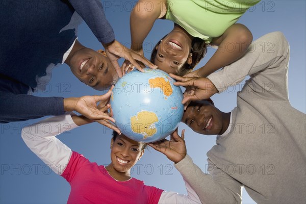 Multi-ethnic hands holding globe