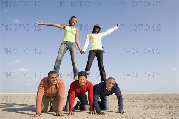 Multi-ethnic friends making human pyramid