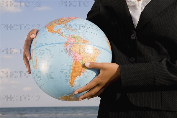 African businesswoman holding globe
