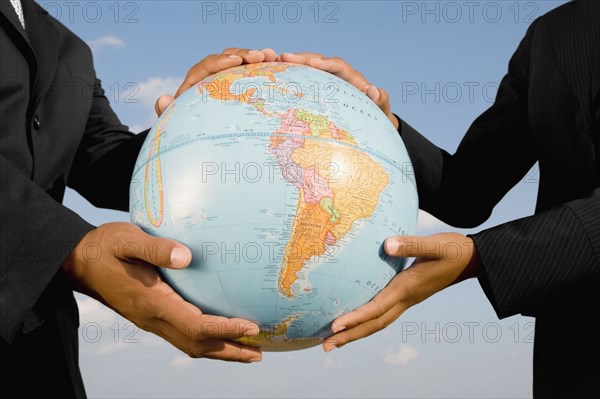 African businesspeople holding globe