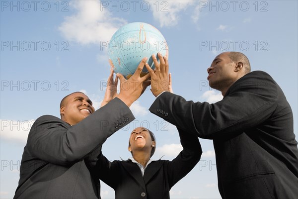 African businesspeople holding up globe
