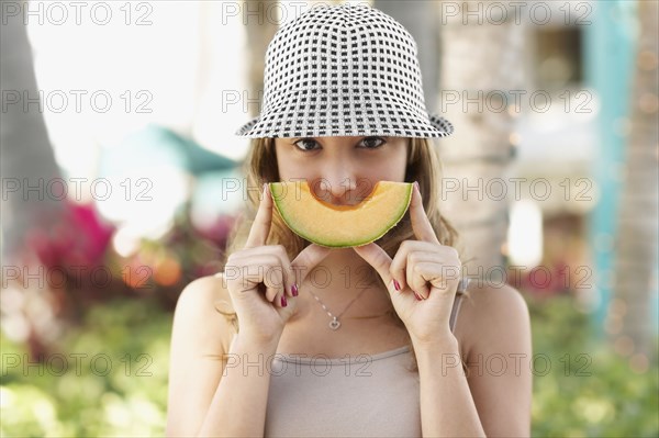 Hispanic woman holding melon slice