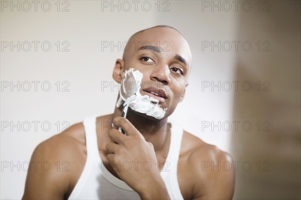 African man shaving face