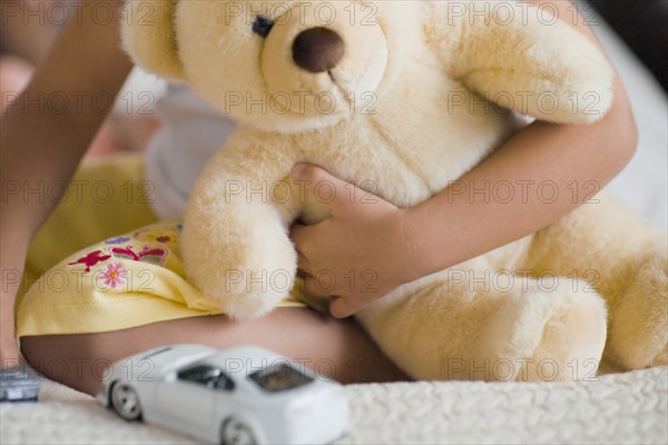 African girl holding teddy bear