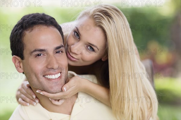Hispanic woman kissing boyfriend's cheek