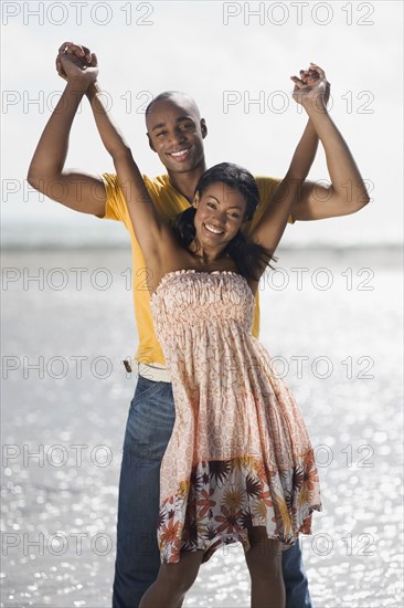 Multi-ethnic couple holding hands at beach