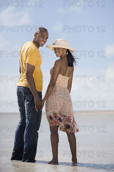 Multi-ethnic couple holding hands at beach