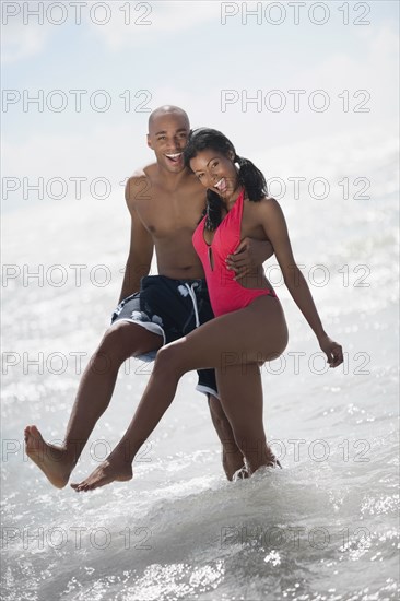 Multi-ethnic couple hugging at beach