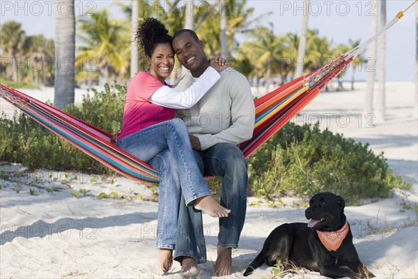 Hispanic couple hugging in hammock