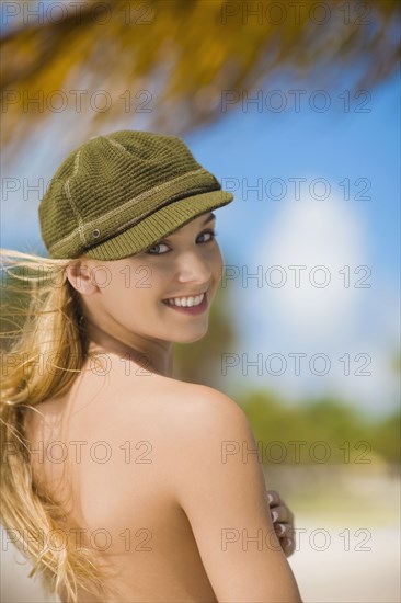 Topless Hispanic woman looking over shoulder