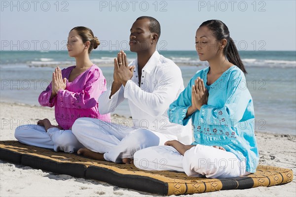 Multi-ethnic friends meditating