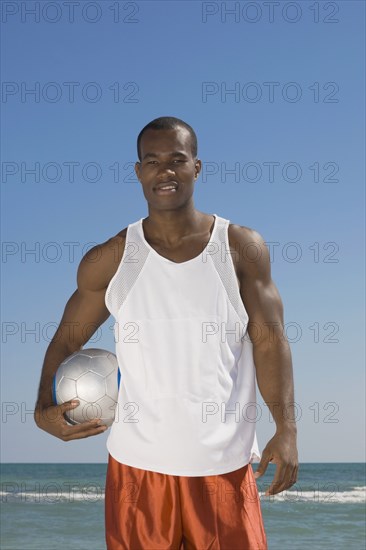 African man holding volleyball