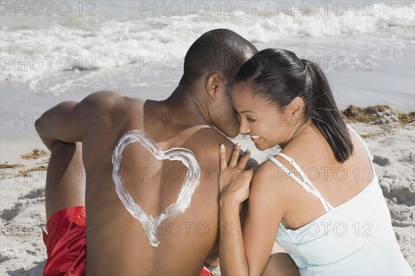 African man with sunscreen heart on back