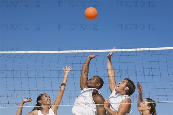 Multi-ethnic friends playing volleyball