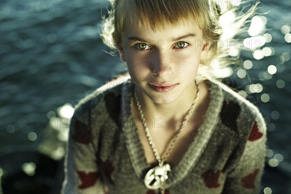 Caucasian girl sitting by water