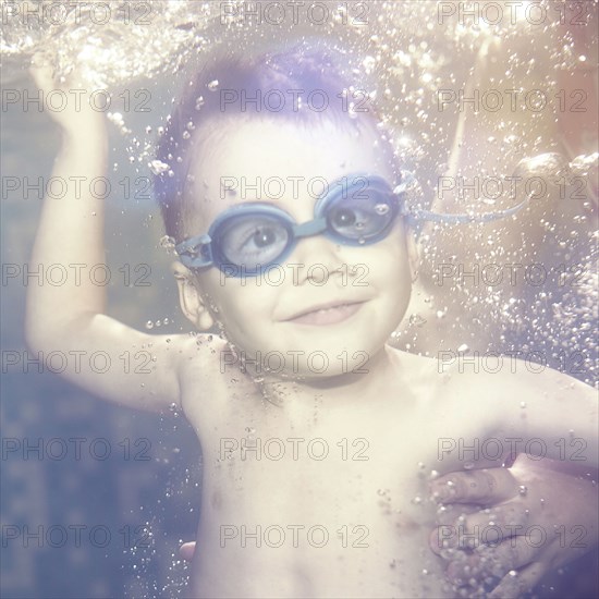 Caucasian boy swimming under water