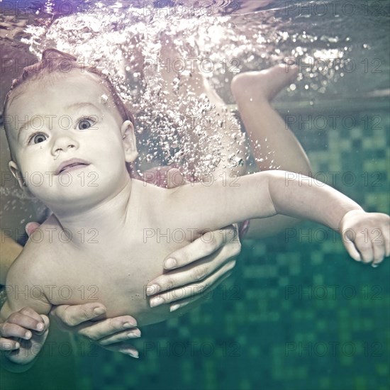 Caucasian baby swimming under water