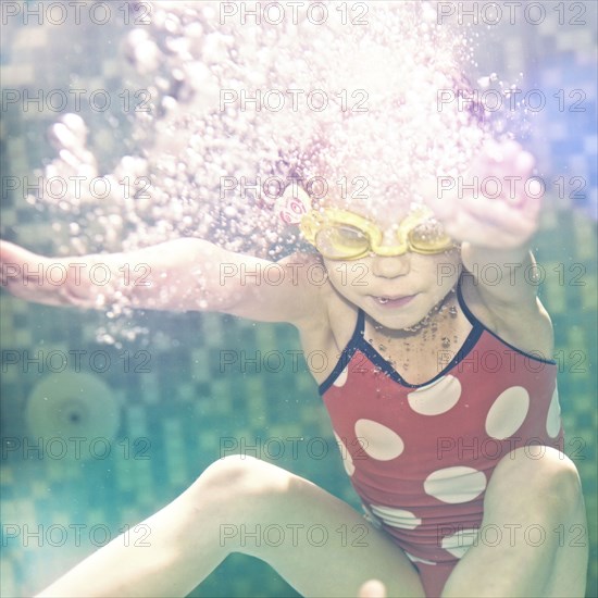 Caucasian girl swimming under water