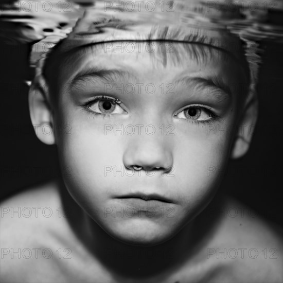 Caucasian boy swimming under water