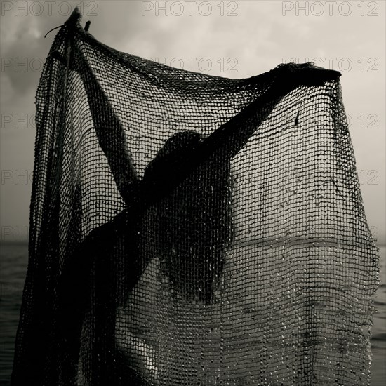 Caucasian girl playing with net on beach