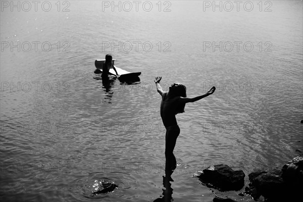 Caucasian girl leaning with head back in lake
