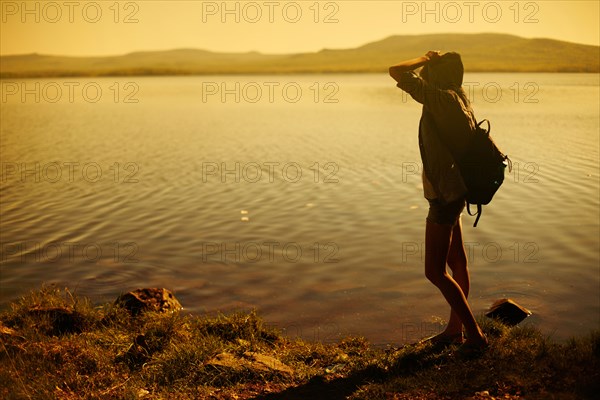 Caucasian woman standing by still rural lake