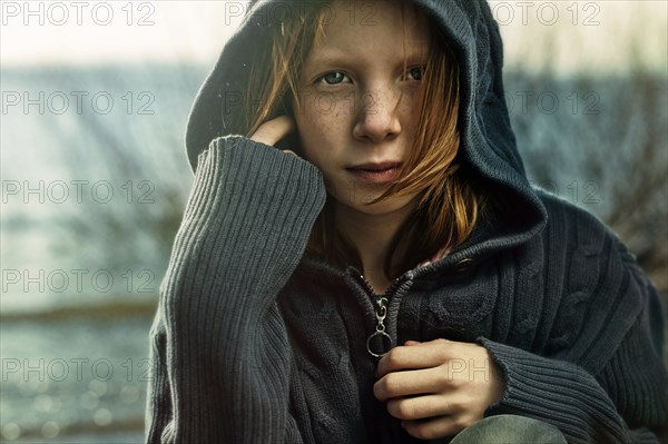 Caucasian girl wearing hooded sweater on beach