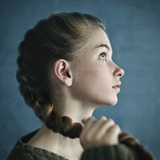 Teenage girl holding braid